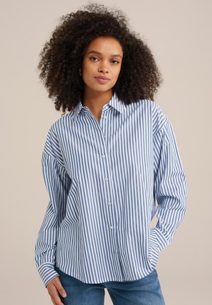 Chemise à carreaux bleus et blancs à boutons avec une coupe décontractée, des manches longues et un col classique. Le tissu semble lisse avec une légère texture.