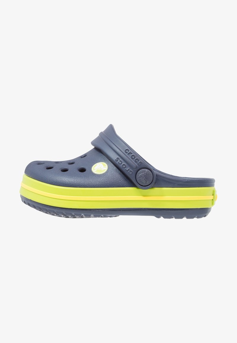 Sabot Crocs bleu marine avec des bandes jaunes sur la semelle, des trous de ventilation et une bride de talon réglable avec le logo Crocs.