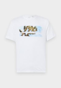 Hvid bomulds t-shirt med et farverigt grafisk design af et Joshua-træ og blå himmel. Korte ærmer, rund halsudskæring og afslappet pasform.