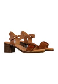 Braune High Heels Sandalen mit überkreuzten Zehenriemen, verstellbarem Knöchelriemen und einer Schnallenakzentuierung. Sie verfügen über einen strukturierten, mittelhohen Blockabsatz.