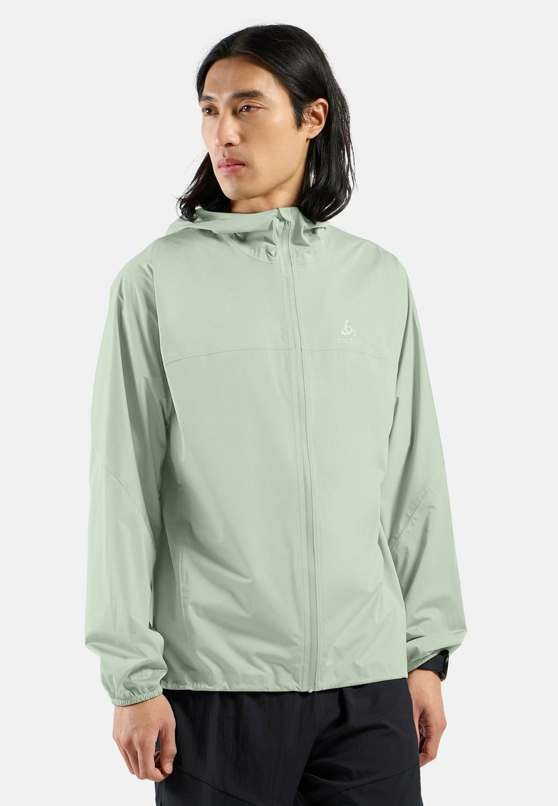 Light green lightweight jacket with a hood, full zipper, and elastic cuffs. Made from smooth fabric, features a logo on the chest.