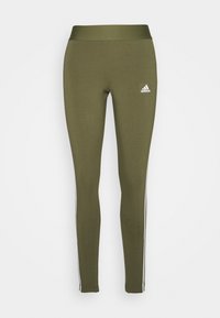 Oliivivihreät leggingsit, jotka on valmistettu joustavasta kankaasta. Niissä on korkea vyötärö ja valkoiset sivuraitat, joissa on Adidas-logo vasemmassa reidessä.