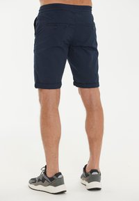 Marineblaue Shorts aus leichtem Stoff, mit umgeschlagenen Saum, zwei Gesäßtaschen mit Knöpfen und einem bequemen elastischen Bund.