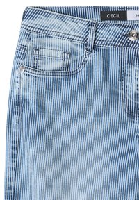 Jean en denim rayé verticalement bleu et blanc avec poche avant, bouton métal et étiquette de marque « CECIL » à la ceinture.