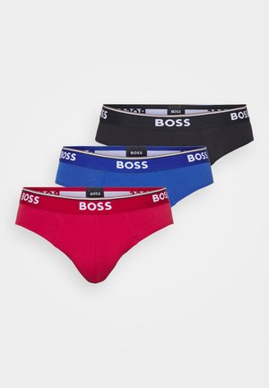 Tres pares de calzoncillos para hombre en rojo, negro y azul, cada uno con una cinturilla de marca a juego que presenta letras blancas.
