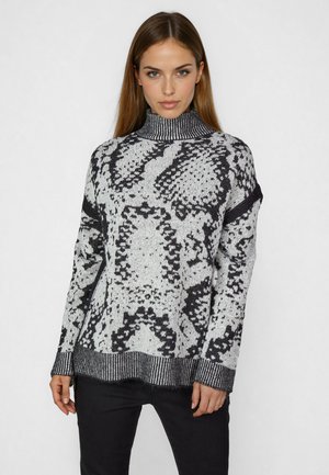 Strickpullover mit Rollkragen in Schwarz-Weiß-Schlangenprint. Mit ribbeltem Kragen und Saum, in lockerer, entspannter Passform.