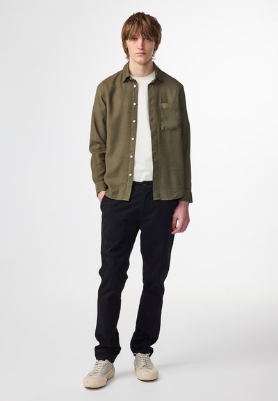 Oliven grøn skjorte med knaplukning og brystlomme, parret med sorte bukser og cremefarvede sneakers. Simpelt design, medium vægt stof, lige pasform.