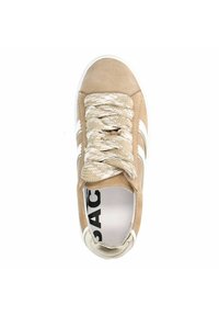 Baskets beiges avec dessus en daim texturé, semelle en caoutchouc blanche et lacets tressés. Présente trois rayures blanches sur le côté.