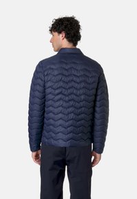 Giacca trapuntata blu navy con motivo a zigzag, colletto a listino e maniche lunghe. Materiale leggero con una texture liscia.