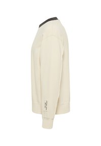 Hellbeige Sweatshirt mit einem dunklen Halsausschnitt, ausgestattet mit einem gerippten Saum und Ärmelbündchen. Es hat ein Seitenschild mit Text in der Nähe des Bündchens.