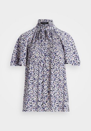 Blusa floral con mangas cortas y sueltas, delantero plisado, cuello alto con volantes y cierre con lazo en colores azul, blanco y lila claro.