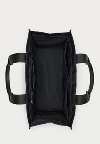 Svart tote-väska med texturerade handtag. Har ett rymligt, öppet inre med ett ficka med dragkedja, stadiga sidor och inga synliga externa detaljer.