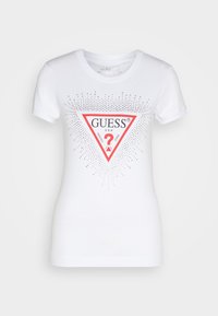 Hvid bomulds t-shirt med et rødt trekantet logo og "GUESS U.S.A." tekst, funklende prikker, der stråler udad, korte ærmer og rund halsudskæring.