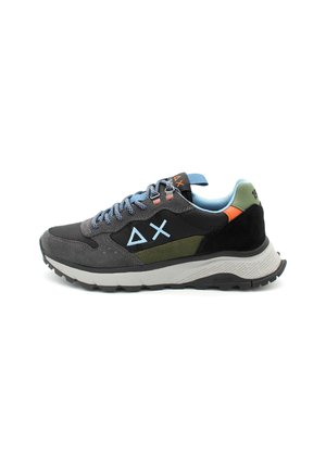 Baskets noires sportives avec des accents bleus et verts, textures en daim et en maille, semelle en caoutchouc grise et logo géométrique unique sur le côté.
