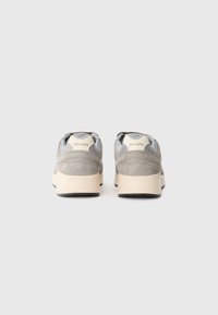 Sneakers in suede grigio con un design testurizzato, featuring un accento azzurro chiaro e una suola in gomma color crema, visibili dalla vista posteriore.