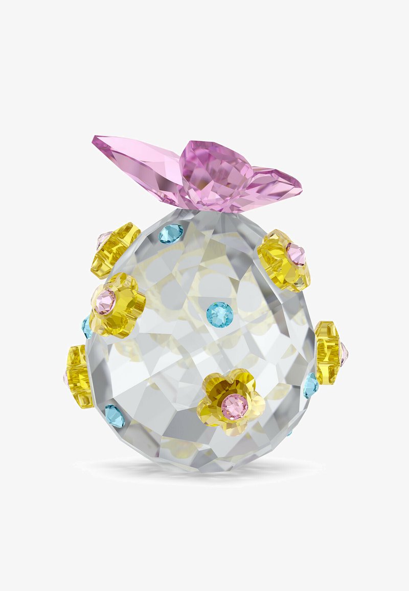 Prozoren kristal z izrazitimi ploskvami, oblikovan kot zavezana vrečka, okrašen z rumenim cvetom in modrimi pikicami iz dragih kamnov, na vrhu pa ima velik rožnat lok.