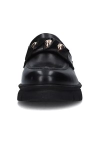 Mocassino in pelle nera con suola spessa, dotato di una fascia decorativa adornata da tre borchie metalliche rotonde sulla parte anteriore.