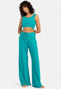 Turkis crop topp og vidbukser i mykt stoff. Toppen har rund hals; buksene har justerbar snor i livet.
