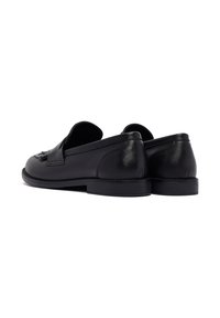 Mocassins en cuir noir avec une texture lisse, une forme arrondie et un profil bas. Dotés d'une décoration à franges à l'avant.