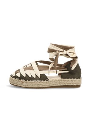 Sandalia espadrille con base de ante verde oscuro, tiras de tela beige cruzadas y suela plataforma de yute trenzado con lazos para atar al tobillo.