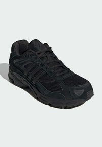 Chaussure de sport noire avec une tige en maille et en nubuck. Présente une semelle rembourrée, un orteil rond et des accents texturés. Design à lacets.