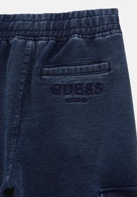Dunkelblaue Jogginghose aus strukturiertem Baumwollgemisch, mit einem elastischen Taillenbund und einer Gesäßtasche mit gesticktem "Guess"-Logo.