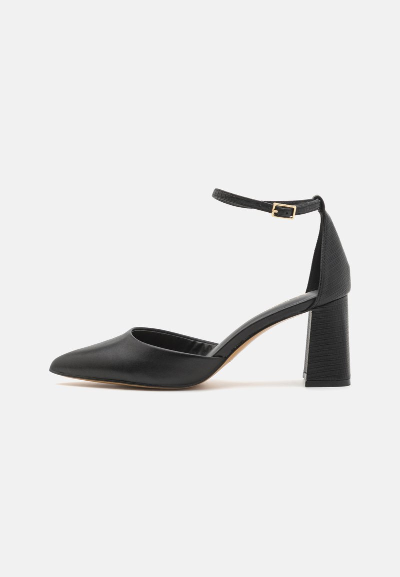 Black high-heeled shoe with a pointed toe, textured ankle strap, and a square block heel. Made of smooth leather.