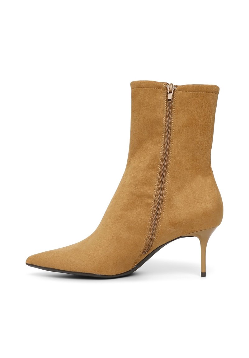 Beige Wildleder-Ankle-Boot mit spitzer Zehenform, seitlichem Reißverschluss und dünnem Absatz. Die glatte Textur und das enganliegende Design betonen das elegante Erscheinungsbild.