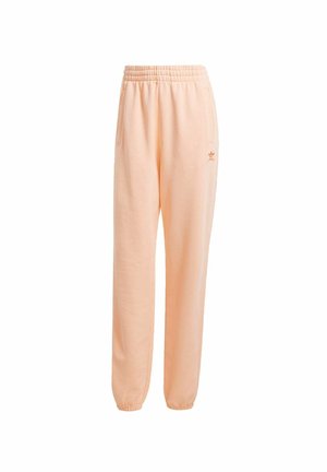 Peach sweatpants with an elastic waistband, side pockets, and a small logo detail. Soft material with a relaxed fit and tapered cuffs.