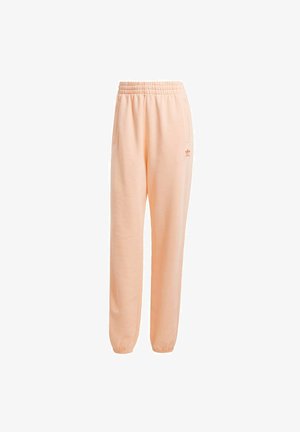 Ružové tepláky s elastickým pásom, bočnými vreckami a malým logom. Mäkko materiál s uvoľneným strihom a zúženými manžetami.