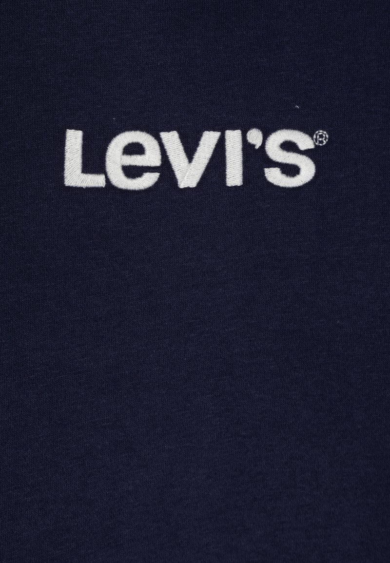 Marineblaue Stoff mit dem gestickten weißen Logo "Levi's", das prominent in der Mitte platziert ist. WeicheTextur mit einem glatten Finish.