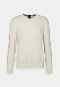 Kremowy sweter z dekoltem w serek wykonany z miękkiej dzianiny, z długimi rękawami i subtelnym haftowanym logo na piersi.