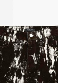 Jean en denim noir et blanc acidulé avec bouton à l'avant, passants de ceinture, poches et étiquette « Massimo Dutti Made in Morocco ».