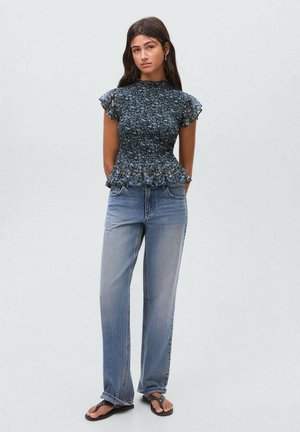 Teksturowana, ciemnoniebieska bluzka peplum z krótkimi falbaniastymi rękawami, połączona z jasnoniebieskimi spodniami typu wide-leg i klapkami. Prosty design, casualowy styl.