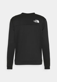 Mustan värinen collegepaita, jossa on tekstuurilla varustettu muotoilu, pyöreä pääntie ja pitkät hihat. Takana on valkoinen logo yläosassa.