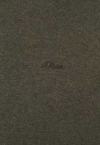 Pull tricot vert olive avec une texture côtelée et une broderie discrète du logo dans une couleur assortie.