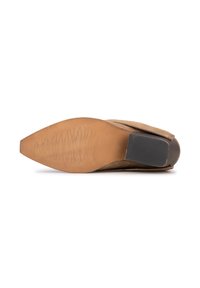 Chaussure en suède marron clair avec un bout pointu et une semelle extérieure texturée couleur tan. Elle présente un petit talon noir, conçue pour une apparence élancée.