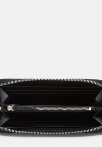 Schwarzes, mit Reißverschluss versehenes Portemonnaie mit mehreren Kartenfächern, einem zentralen, mit Reißverschluss verschließbaren Fach und einer strukturierten Außenseite mit silbernen Hardware-Akzenten.