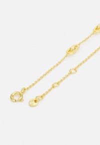 Pulsera de cadena de metal en tono dorado que presenta una mezcla de eslabones ovalados y redondos, con un cierre de langosta y un detalle de colgante para un ajuste seguro.