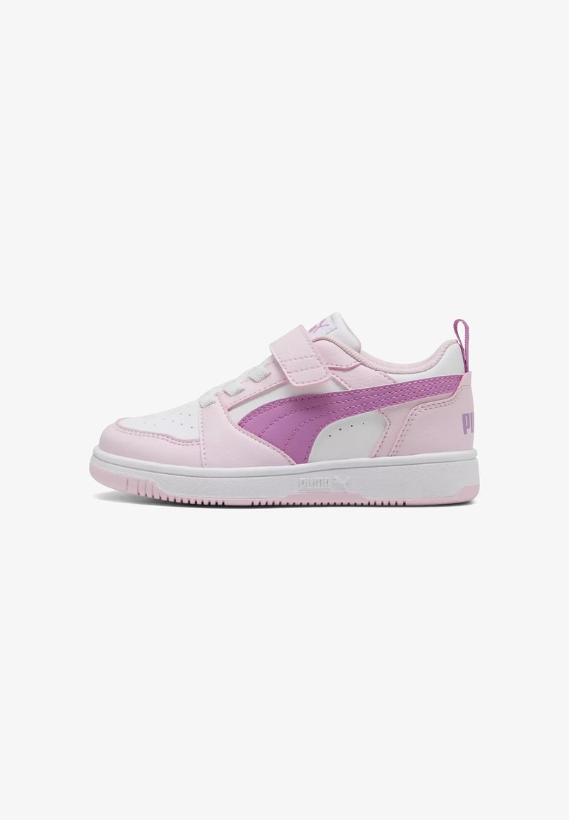 Baskets basses Puma blanches et rose clair avec une bande violette, fermeture velcro et semelle blanche, conçues pour un usage décontracté.