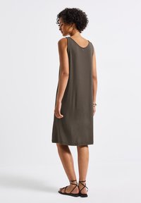 Bezrekawnikowa sukienka w oliwkowym kolorze, uszyta z miękkiej tkaniny, z okrągłym dekoltem, gładką fakturą i drobnym guzikiem z tyłu.