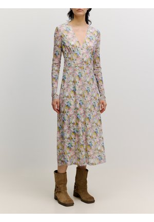Blumen langärmliges Kleid mit V-Ausschnitt, in zarten Farben und mit tailliertem Oberteil. Getragen mit braunen Stiefeletten. Glatte Stoffstruktur.