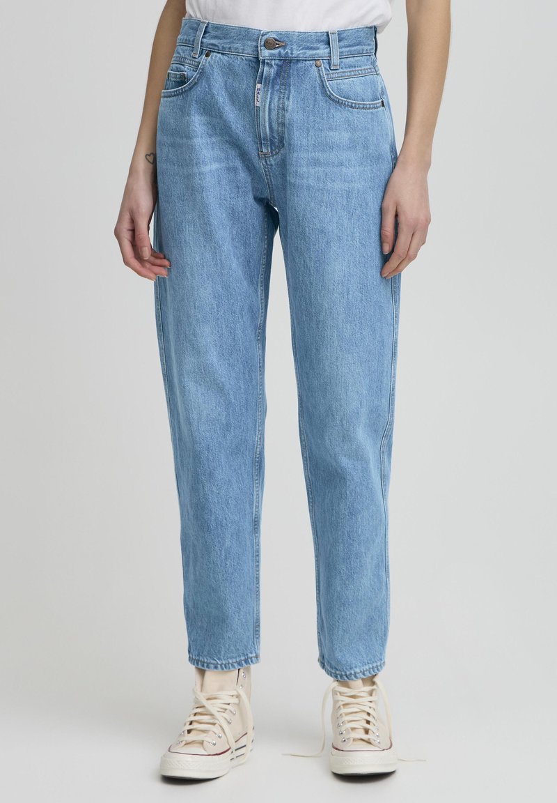 Jeans de mezclilla de color azul claro con cintura alta, pierna recta y diseño de cinco bolsillos. Presentan un ligero desgastado y herrajes de botón metálico.