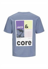 Kortärmad, blå bomullströja med en fyrkantig grafik på baksidan i pastellfärger och fet svart text, "JACK & JONES core."