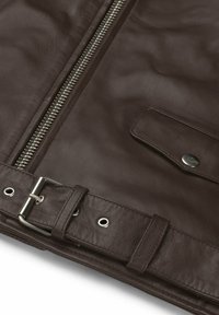 Brun läderjacka med en silverdragkedja, tryckknappsfickor och ett bälte med spänne i metall, som visar upp ett texturerat material och detaljerad sömnad.