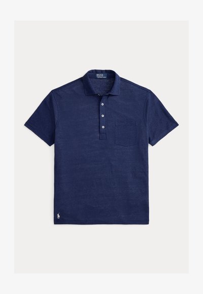 Μπλε ναυτικό πόλο με υφή υφάσματος, με γιακά, πατιλέτα με τρία κουμπιά και τσέπη στο αριστερό στήθος. Μικρό λογότυπο στο τελείωμα.