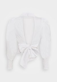 Blusa bianca con scollatura a V profonda, maniche a palloncino e polsini arricciati. Presenta un dettaglio a fiocco in vita, realizzata in un tessuto morbido.