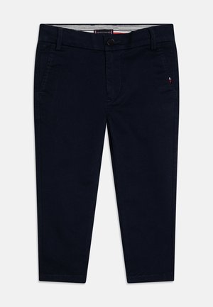Chino in cotone blu navy con taglio dritto, dotati di due tasche frontali e un piccolo logo ricamato. Chiusura con bottone e fascia interna a righe.