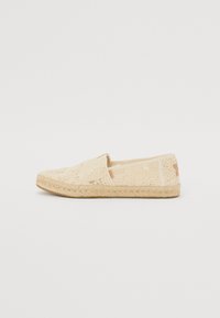 Béžové espadrilky s krajkovým potahem, kulatou špičkou a juteovou podešví. Klouby styl s prošitými detaily a minimálním označením na boku.