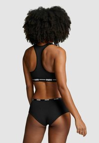 Schwarzes Sport-BH- und Slips-Set mit Racerback-Design. Ausgestattet mit einem Puma-Logo-Band und glattem, dehnbarem Stoff.